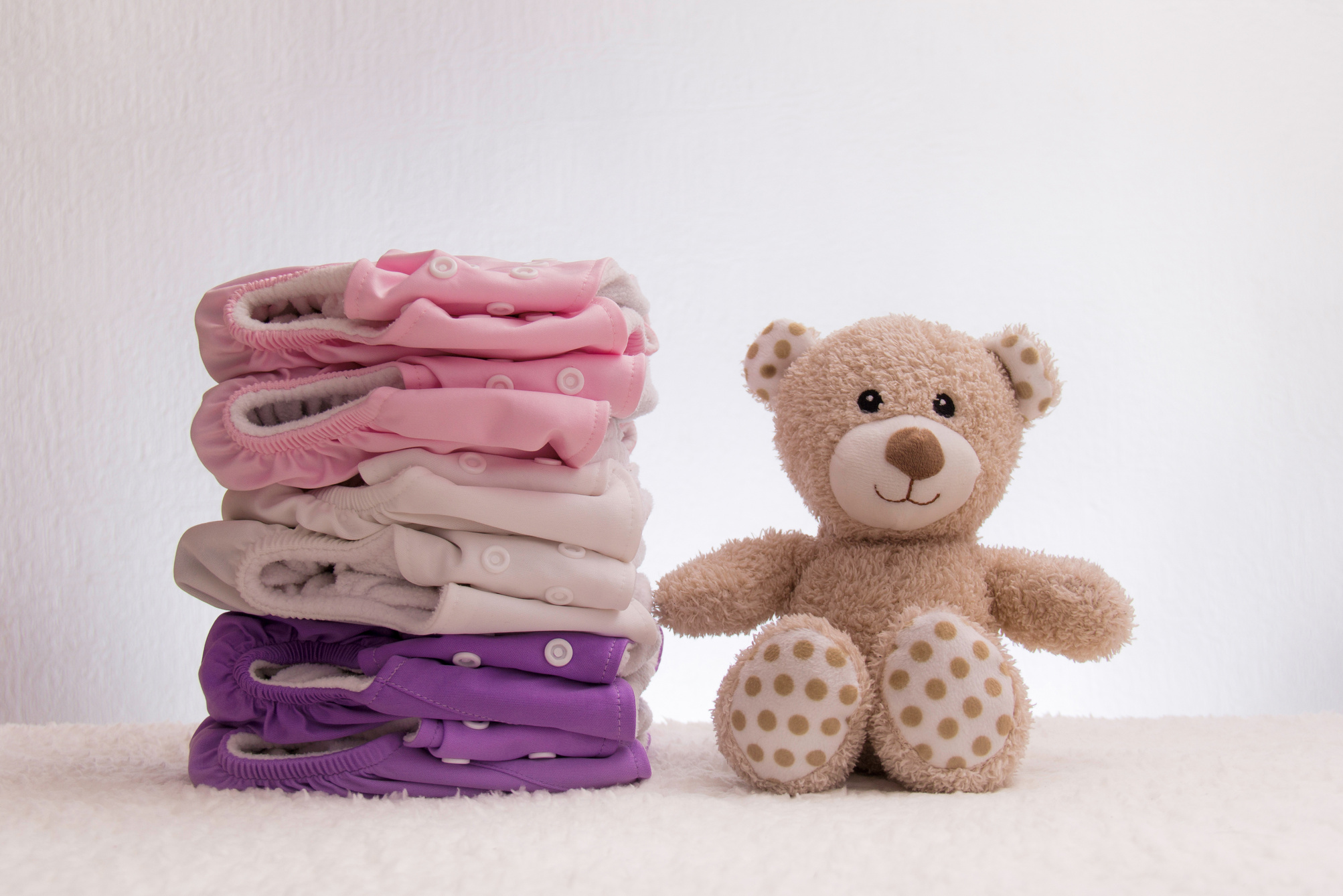 Cloth diapers stacked with a teddy bear